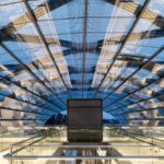 a glass ceiling in a building with a sky background